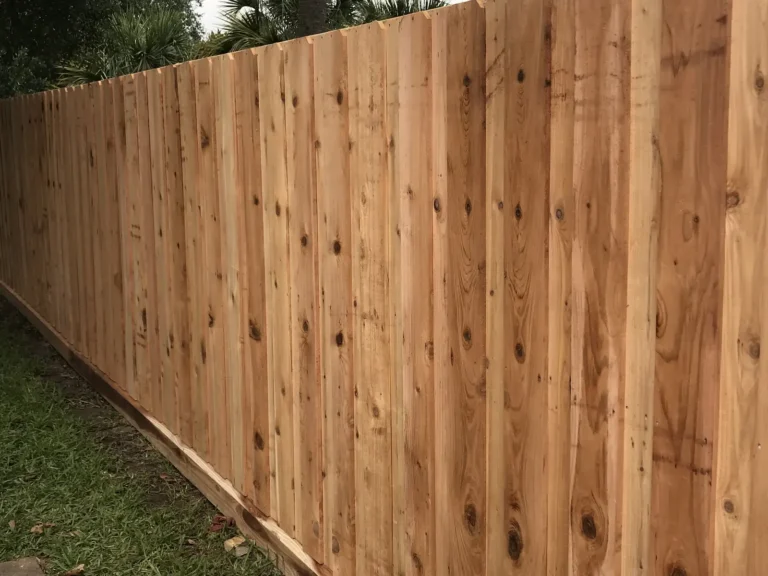 New cedar privacy fence with side-by-side boards and a bottom rot board
