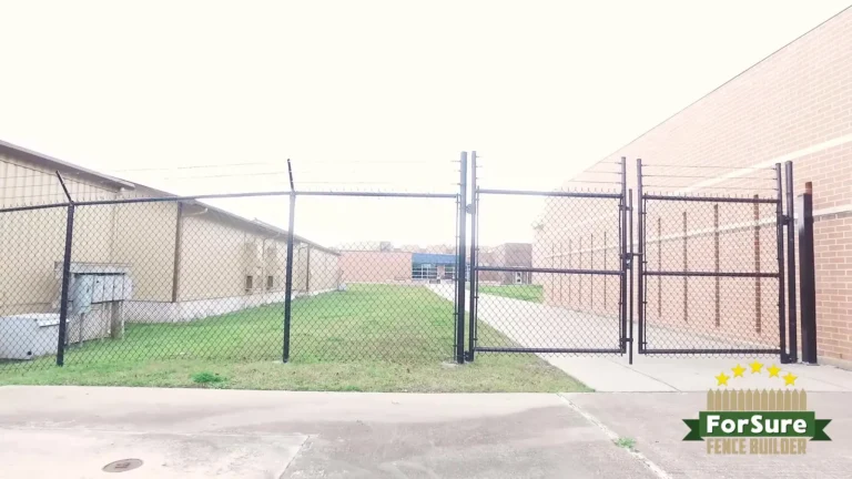 Chain link fence with double swing gates between commercial buildings