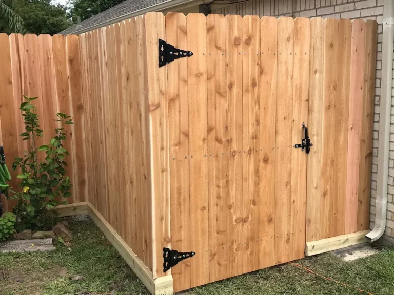 Dog-ear cedar fence gate with black hinges and latch