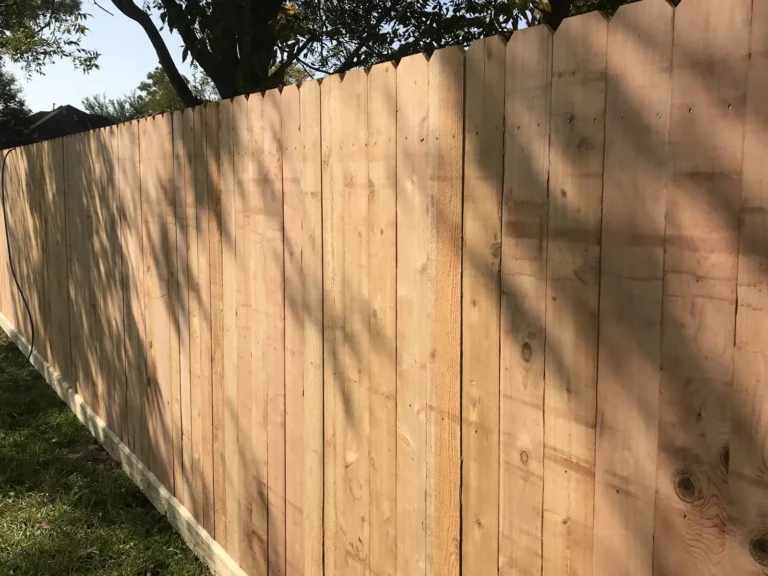 New dog-ear wood privacy fence along a backyard