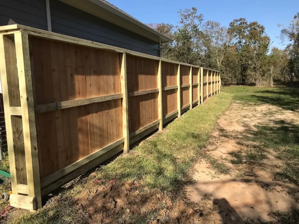 Framed and capped cedar privacy fence along a side yard