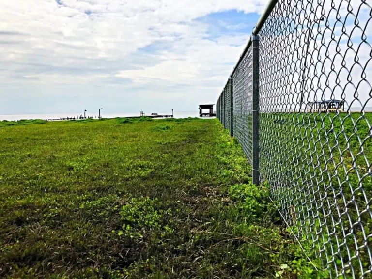 Galvanized chain link fence along an open field