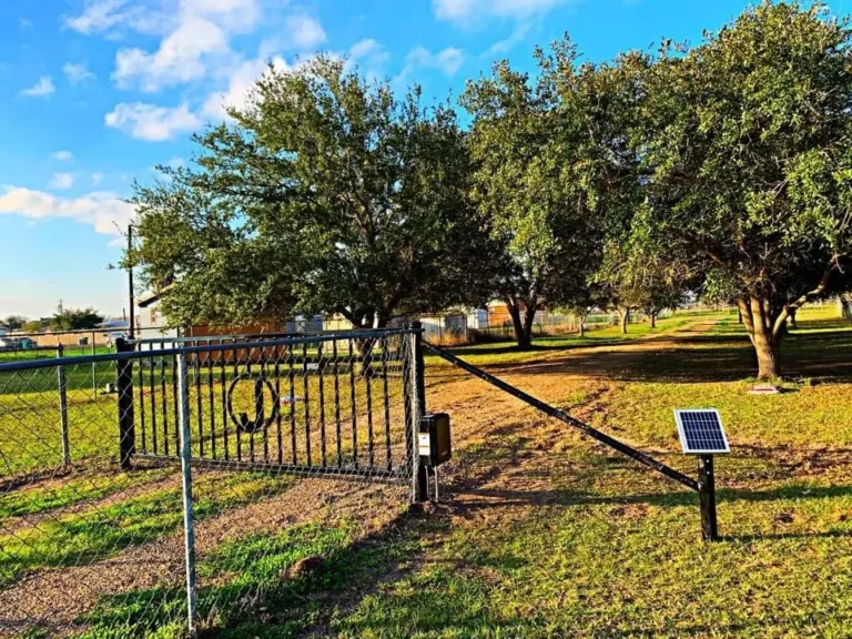 Black ornamental iron entry gate with a solar-powered automatic opener