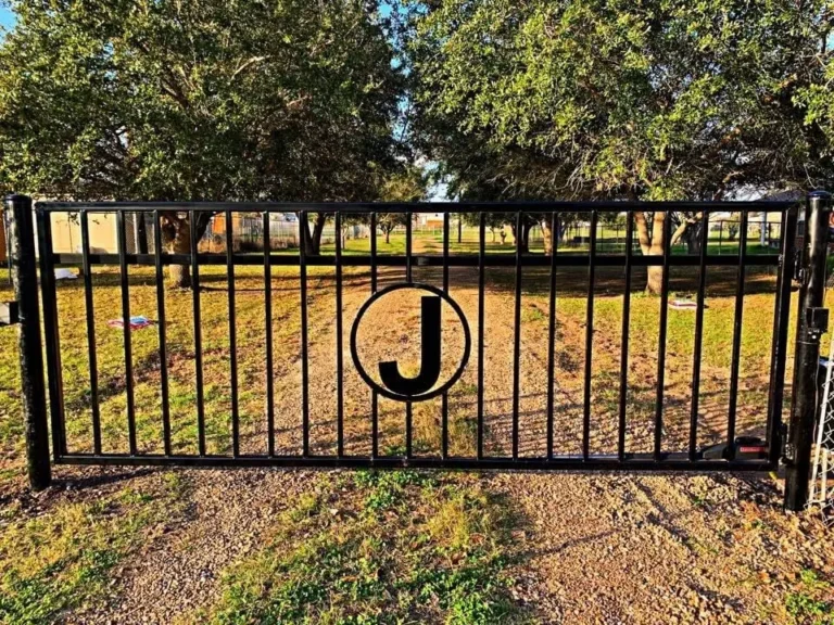 Black ornamental iron fence panel with a custom "J" monogram