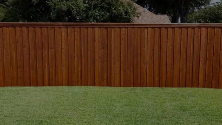 Stained wood privacy fence enclosing a grassy backyard