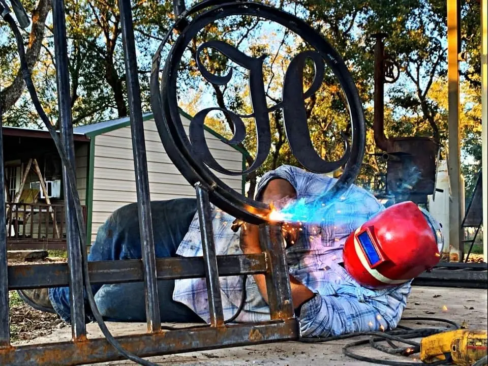 Welder fabricating a custom monogram iron gate