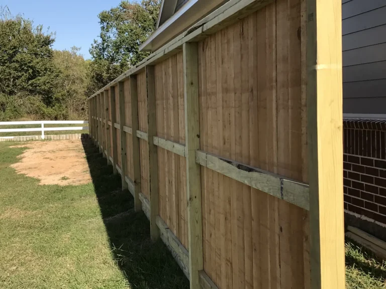 Side view of a wood privacy fence showing posts and rails