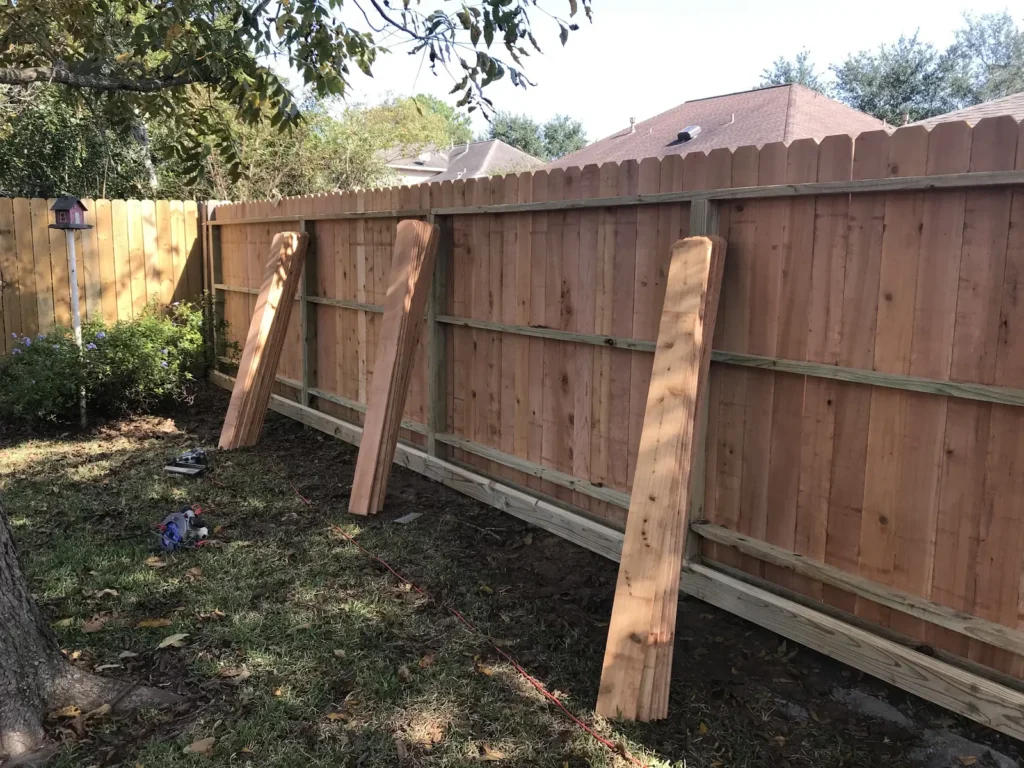 Wood fence repair with temporary bracing while new posts set