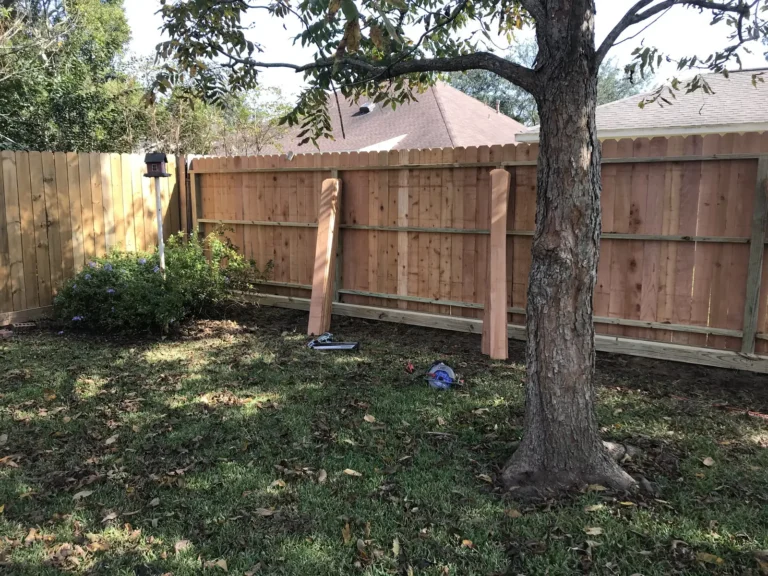 Leaning wood fence being straightened and braced during a repair