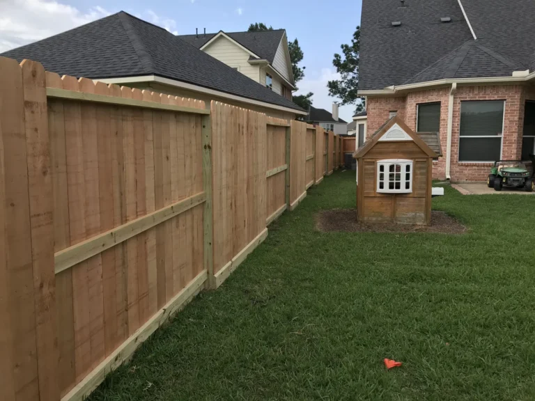 Wood privacy fence around a backyard with a children's playhouse