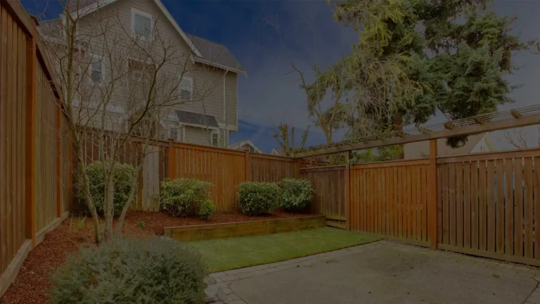 Wood privacy fence surrounding a landscaped backyard