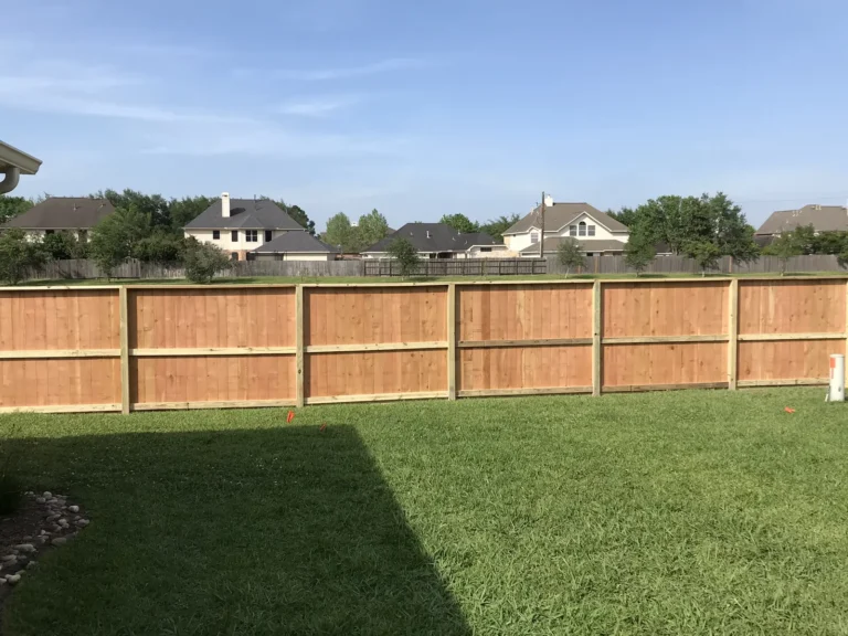 Wood privacy fence around an open backyard with neighboring homes beyond
